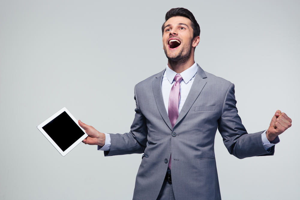 Happy businessman celebrating his success over gray background